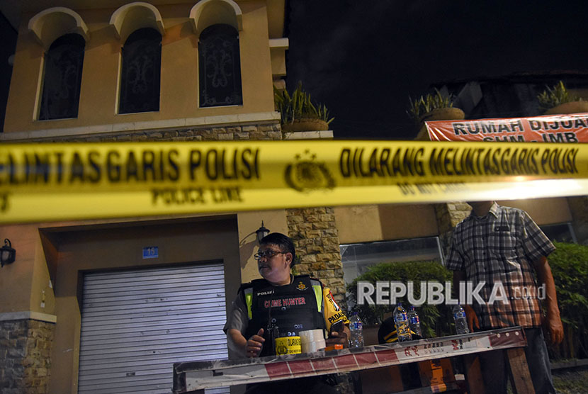 Polisi berjaga di depan sebuah rumah usai penangkapan terduga teroris di kawasan Dukuh Pakis, Surabaya, Jawa Timur, Selasa (15/5).