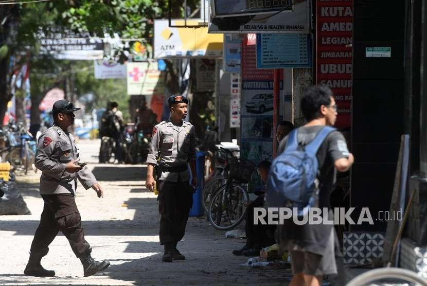 Polisi berjaga di depan toko yang tutup di Gili Trawangan, Lombok Utara, NTB, Kamis (9/8). 