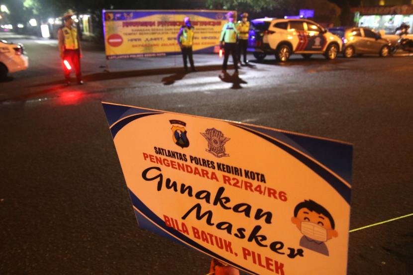 Polisi berjaga di Jalan PK Bangsa, Kota Kediri, Jawa Timur, Sabtu (28/3/2020) malam. Polresta Kediri mentup Jalan PK Bangsa untuk memberlakukan kawasan 