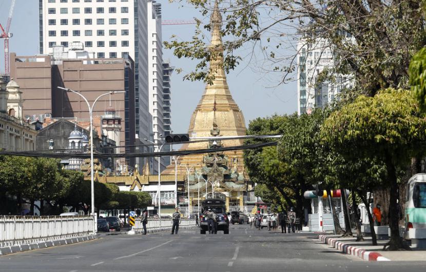 Polisi berjaga di jalanan yang lengang di Yangon, Myanmar pada Selasa (1/2/2022). Warga sengaja memilih diam di rumah masing-masing peringati setahun kudeta Myanmar.