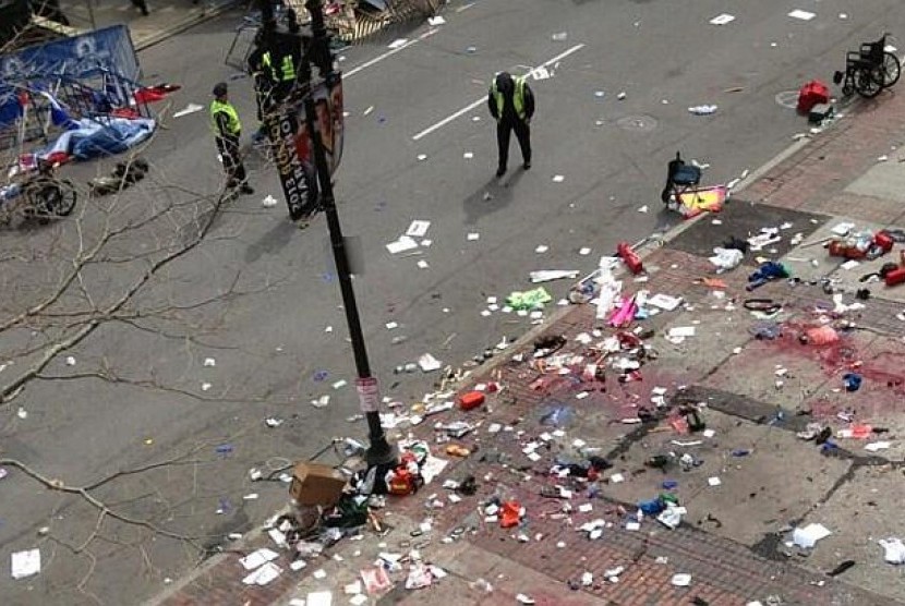 Polisi berjaga di lokasi ledakan dua bom kembar di dekat garis finis perlombaan Maraton Boston 2013, Senin 15 April 2013