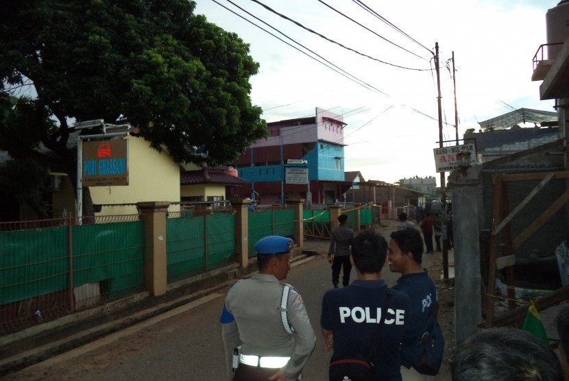 Polisi berjaga di lokasi penggerebakan sebuah rumah di Bintara Jaya, Bekasi, Sabtu (10/12). Di rumah bertingkat tiga bercat biru dan pink itu ditemukan benda diduga bom.