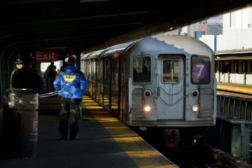 Polisi berjaga di peron Stasiun 40th Street-Lowery Street, New York, di mana seorang pria didorong dan tewas dilindas kereta 7.