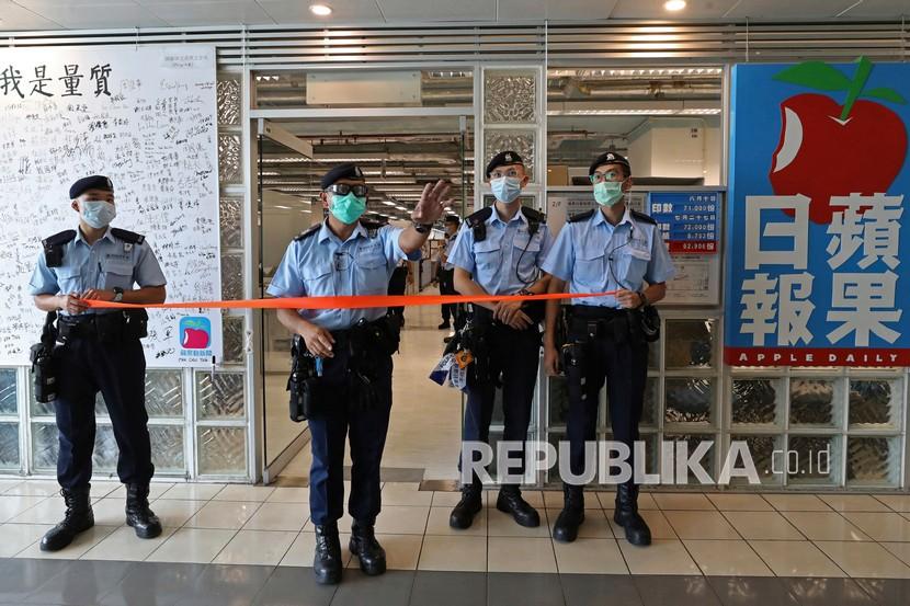 Polisi berjaga di pintu masuk markas Apple Daily saat pendiri surat kabar Jimmy Lai ditangkap oleh petugas polisi di rumahnya di Hong Kong, Senin (10/8/2020).