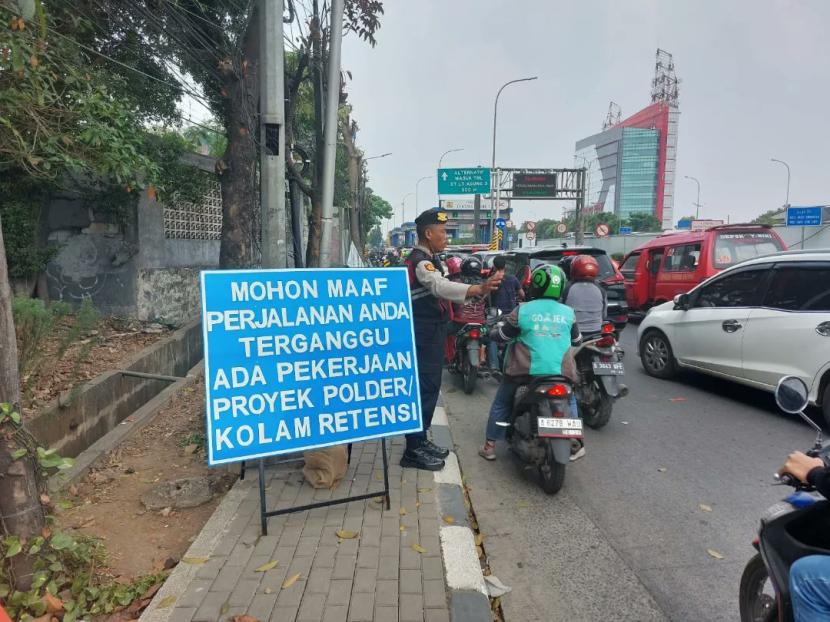 Polisi berjaga di proyek polder Jalan TB Simatupang, Kecamatan Jagakarsa, Jakarta Selatan, yang memicu kemacetan akibat penyempitan jalan.