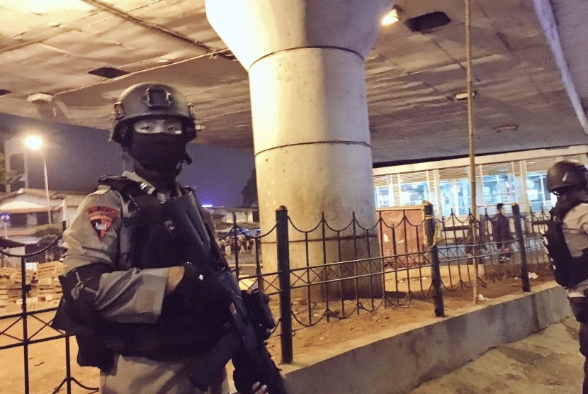 Polisi berjaga di tempat kejadian perkara ledakan bom di dekat Terminal Kampung Melayu, Jakarta, Rabu (24/5).