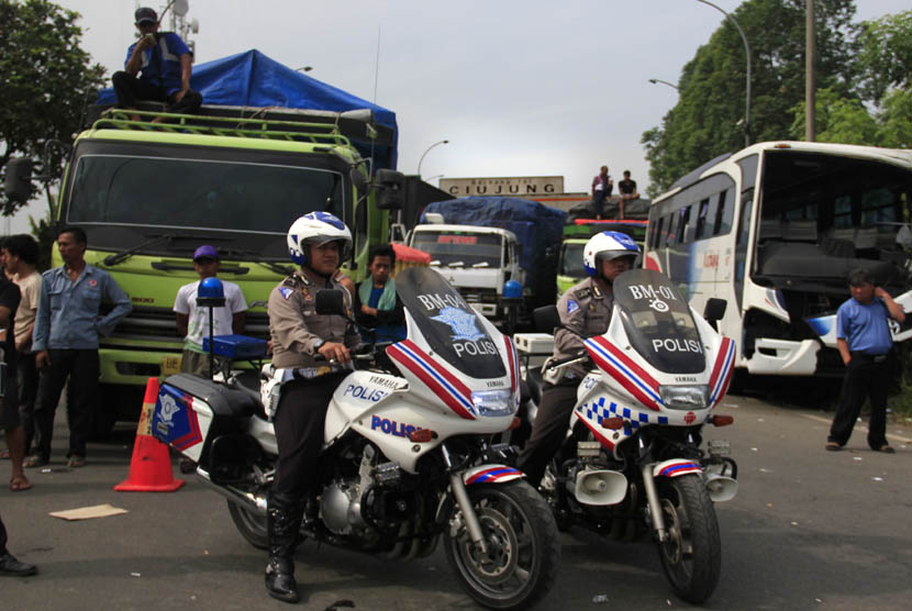  Polisi berjaga diantara kemacetan panjang kendaraan dari Serang menuju Jakarta yang macet total akibat diblokir buruh di gerbang Tol Jakarta-Merak KM-57, Ciujung, Serang, Banten, Selasa (3/12).  (Antara/Asep 