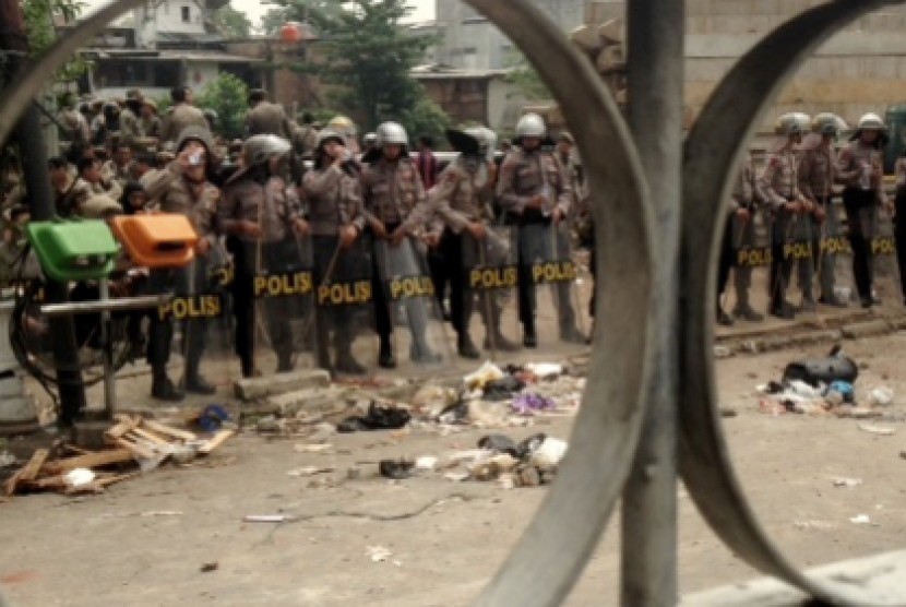 Polisi berjaga dilokasi kericuhan relokasi Kampung Pulo, Jakarta Timur