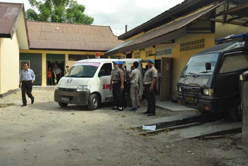  Polisi berjaga disekitar ambulance yang membawa jenazah terduga teroris saat akan dibawa pihak keluarga ke Kabupaten Poso dari RS Bhayangkara Palu, Sulawesi Tengah, Selasa (11/6). 
