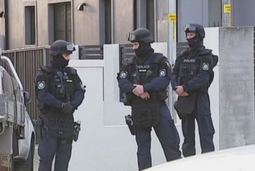 Polisi berjaga-jaga di depan sebuah rumah di daerah Merrylands, di Sydney Barat, Rabu (7/10).