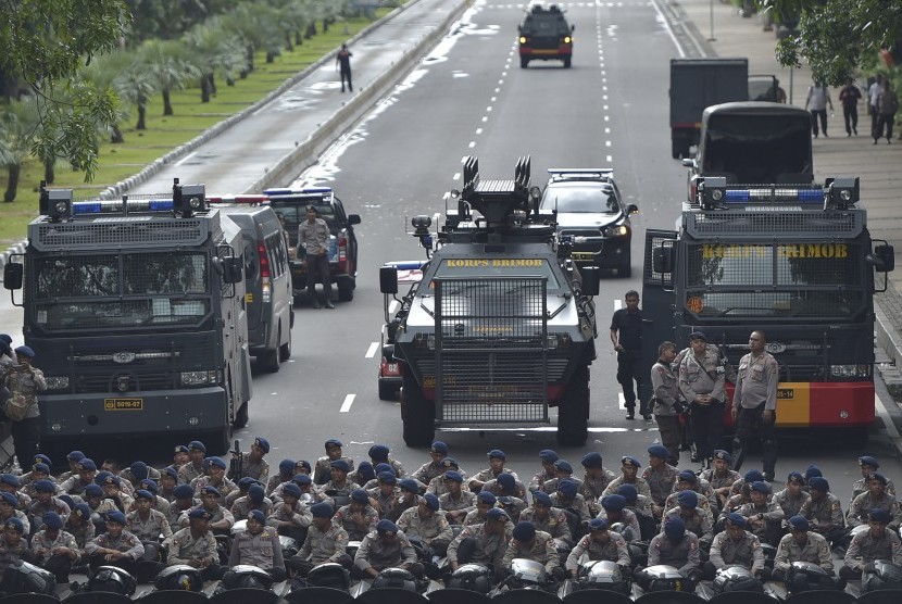 Polisi berjaga-jaga sebagai bagian dari pengamanan Aksi 313 di Jalan Medan Merdeka Barat, Jakarta, Jumat (31/3).
