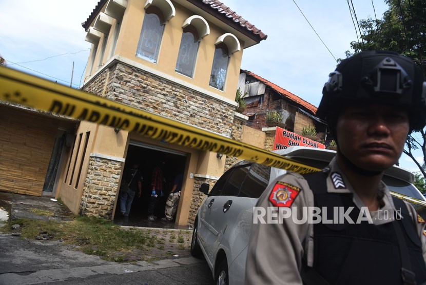 Polisi berjaga saat berlangsung penggeledahan di rumah terduga teroris di kawasan Dukuh Pakis, Surabaya, Jawa Timur, Kamis (17/5). 