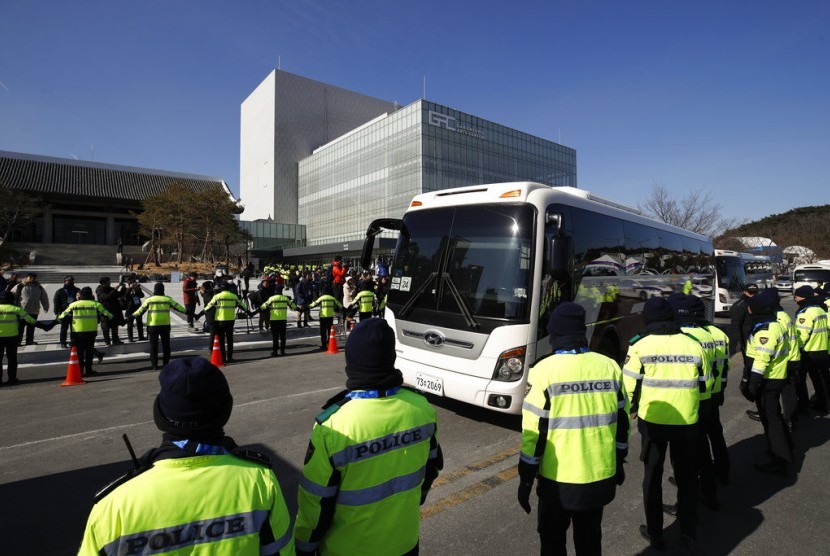 Polisi berjaga saat bus yang membawa rombongan seniman Samjiyon dari Korea Utara menjelang Olimpiade Musim Dingin di Gangneung, Korea Selatan, Rabu (7/2).