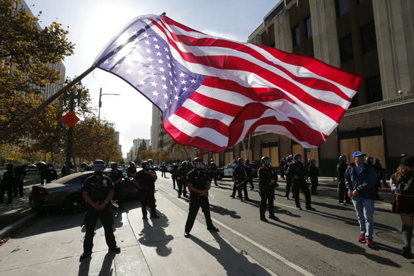 Polisi berjaga saat masyarakat Amerika merayakan kemenangan Presiden AS terpilih Joe Biden dan wakilnya Kamala Harris di jalanan Los Angeles, Sabtu (7/11) waktu AS. 