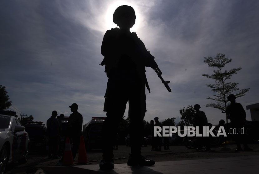 Polisi berjaga saat pemindahan jenazah terduga pelaku teror dari ruang pendingin ke ambulans di RS Bhayangkara, Surabaya, Jawa Timur, Jumat (18/5). 