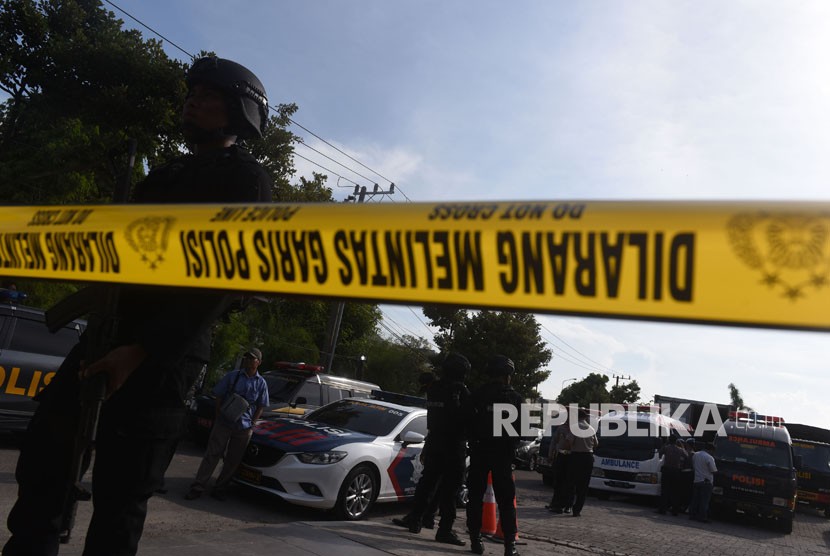Polisi berjaga saat pemindahan jenazah terduga pelaku teror dari ruang pendingin ke ambulans di RS Bhayangkara, Surabaya, Jawa Timur, Jumat (18/5).