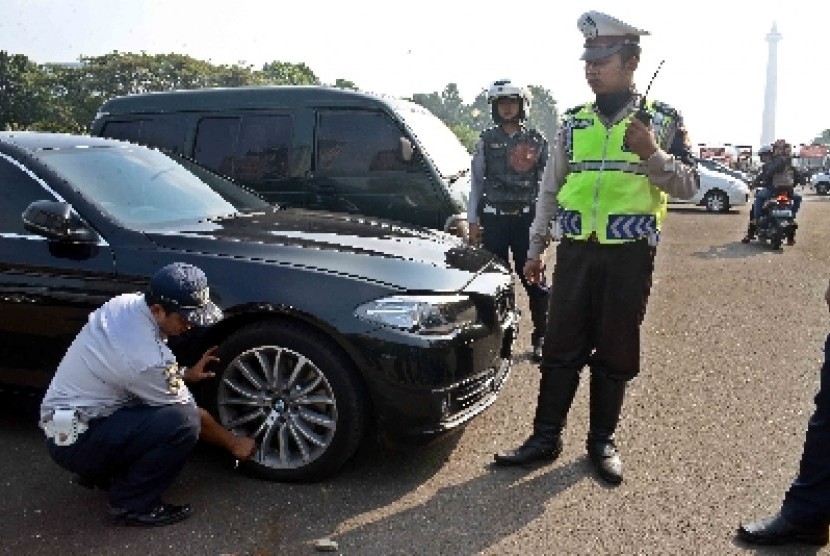 Polisi bersama Dinas Perhubungan melakukan pemeriksaan terhadap mobil yang terparkir sembarangan di Monas.