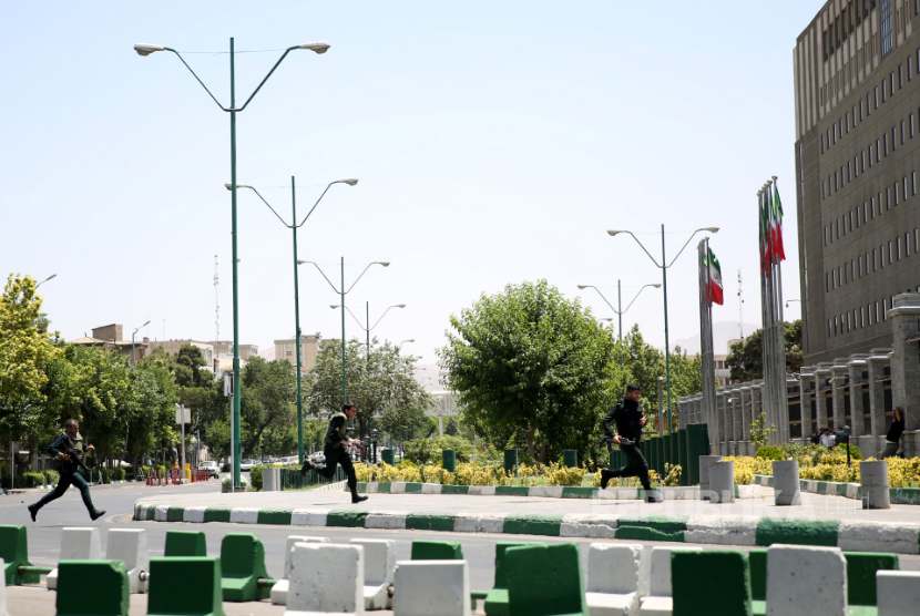 Polisi bersenjata berlari di sekitar kompleks Parlemen Iran yang diserang kelompok bersenjata, Rabu (7/6)