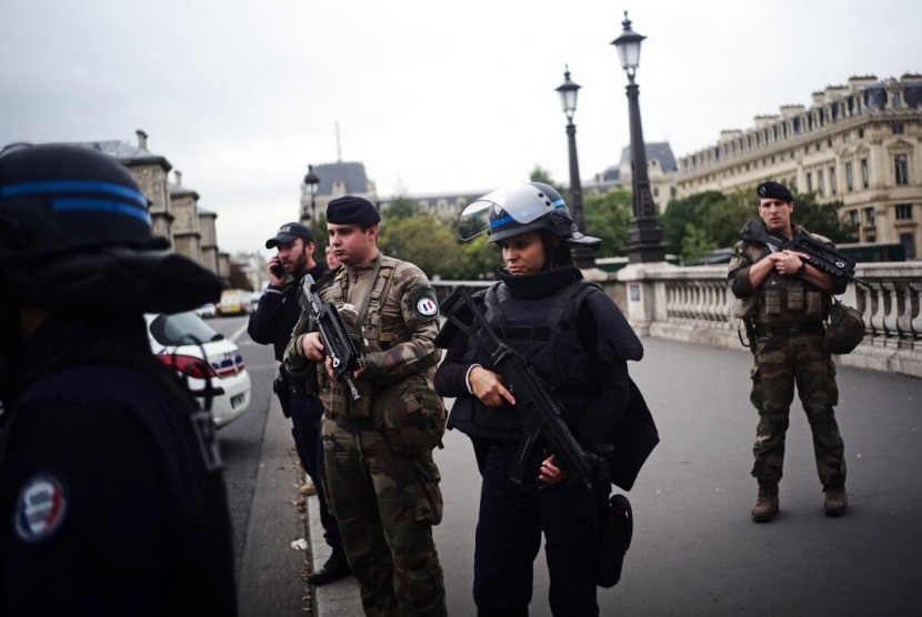 Polisi bersenjata dan tentara berjaga setelah penikaman polisi di markas polisi di Paris, Kamis (3/10). Insiden itu menewaskan empat polisi.