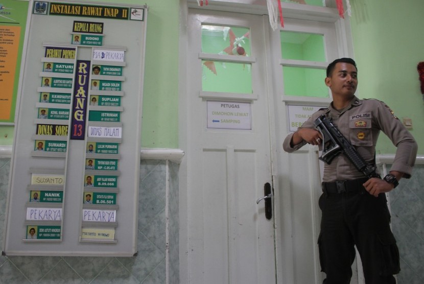 Polisi bersenjata laras panjang melakukan penjagaan di ruang perawatan korban penganiayaan kasus tambang Lumajang yang bernama Tosan di Rumah Sakit Saiful Anwar, Malang, Jawa Timur, Kamis (1/10).