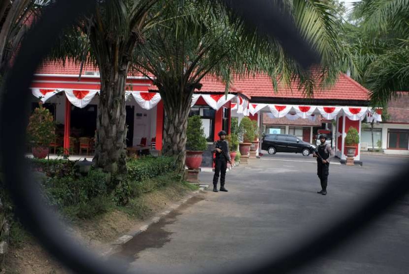 Polisi bersenjata lengkap berjaga di halaman Rumah Dinas (Rumdin) Wali Kota Blitar saat penyidik KPK melakukan penggeledahan lanjutan di Kota Blitar, Jawa Timur, Selasa (4/9). 