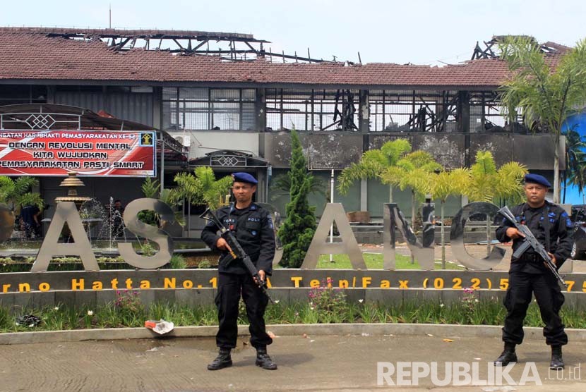 Polisi bersenjata laras panjang melakukan penjagaan ketat pasca kebakaran yang terjadi di Lembaga Pemasyarakatan Kelas IIA Banceuy, Kota Bandung, Ahad (24/4). (Republika/Dede Lukman Hakim)