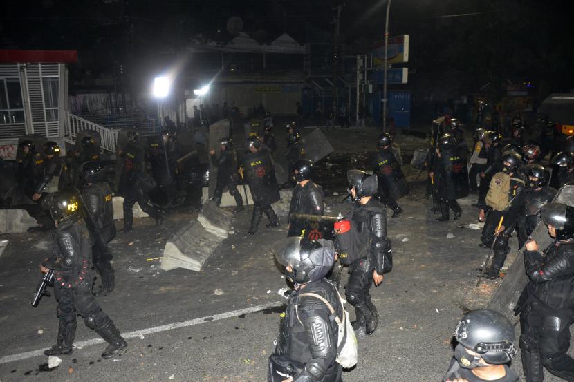 Polisi berusaha membubarkan aksi unjuk rasa mahasiswa di depan kampus Universitas Muhammadiyah (Unismuh) Makassar, Sulawesi Selatan, Jumat (9/10/2020) dini hari. Bentrokan terjadi saat polisi berusaha membubarkan aksi mahasiswa menolak Undang-undang (UU) Cipta Kerja.
