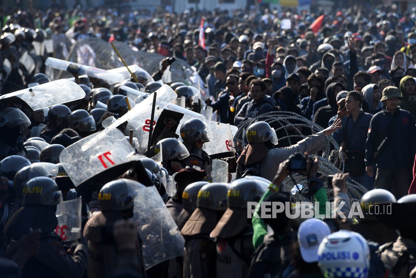 Polisi berusaha menenangkan mahasiswa yang tergabung dalam Aliansi Mahasiswa Jawa Timur saat aksi unjuk rasa di depan gedung DPRD Jatim, Surabaya, Jawa Timur, Kamis (26/9/2019). 