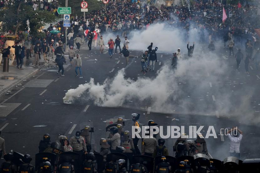 Polisi berusaha menghalau serangan pengunjuk rasa saat demo menolak Undang-undang Cipta Kerja di depan Gedung Negara Grahadi, Surabaya, Jawa Timur, Kamis (8/10/2020). Aksi yang dikuti ribuan orang dari berbagai elemen mahasiswa dan buruh tersebut berakhir ricuh dan mengakibatkan sejumlah fasilitas umum rusak.