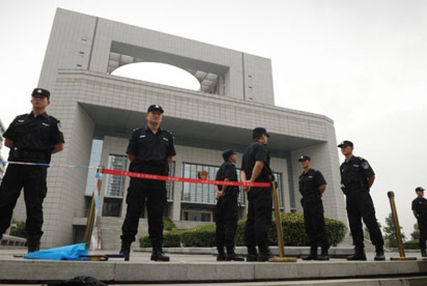 Polisi Cina bersiaga menjaga pengadilan tempat persidangan 4 kolega mereka digelar.