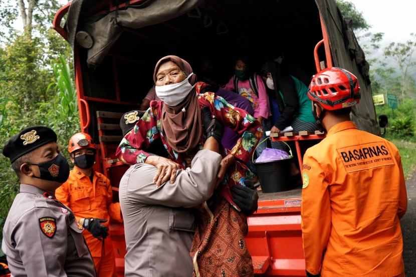 Polisi dan Basarnas membantu pengungsi Gunung Merapi turun dari truk di Turgo, Sleman, D.I Yogyakarta, Selasa (9/2/2021). Ratusan warga Turgo yang mengungsi sejak dua pekan terakhir kembali ke rumah menyusul rekomendasi jarak aman bahaya erupsi Gunung Merapi dari BPPTKG. 