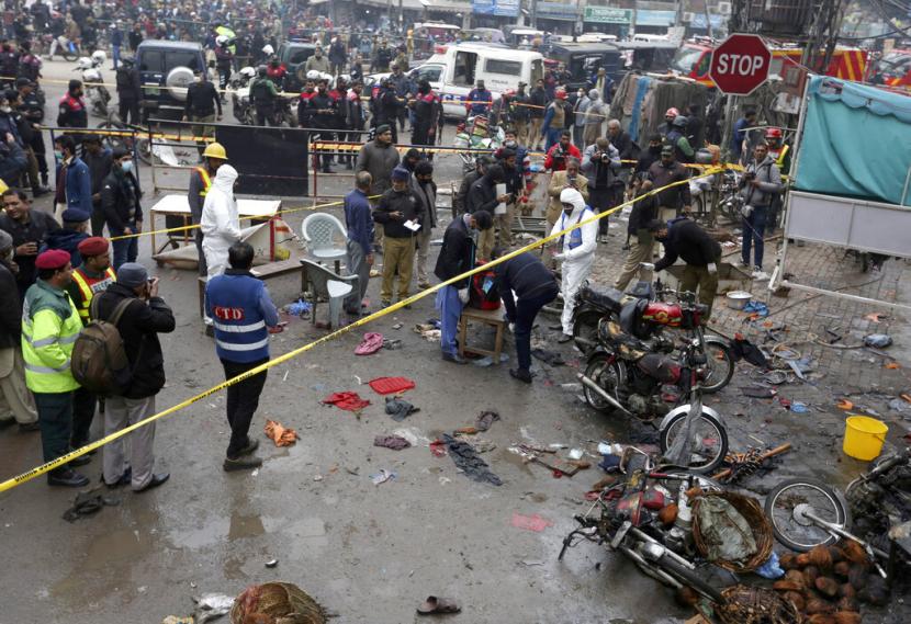 Polisi dan penyidik memeriksa lokasi ledakan bom di Lahore, Pakistan, Kamis (20/1/2022). Polisi mengatakan bom berkekuatan besar meledak di pasar yang ramai di Lahore.