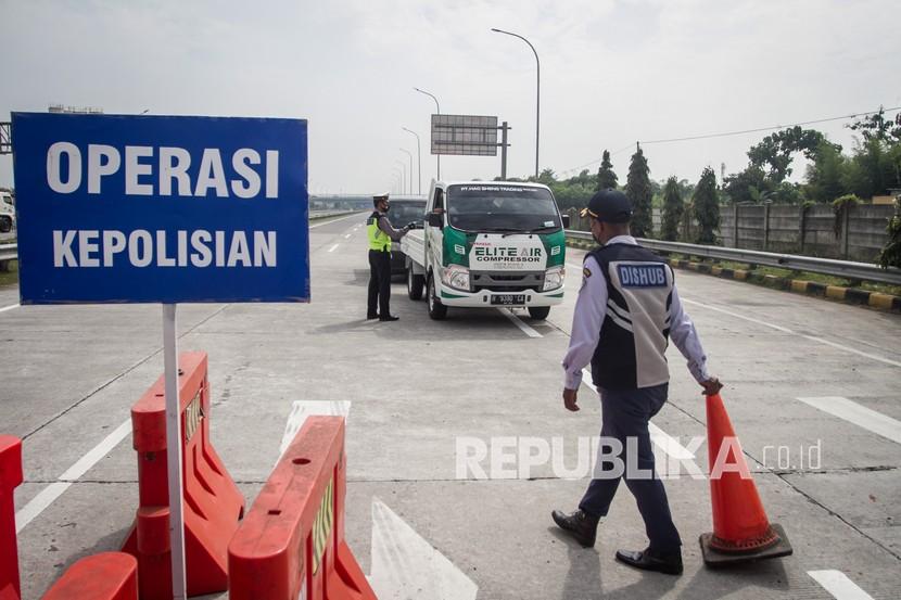 Polisi dan petugas Dinas Perhubungan memeriksa dokumen syarat melakukan perjalanan pengemudi yang keluar tol saat dilakukan Penyekatan Kendaraan di Pintu Tol Colomadu, Karanganyar, Jawa Tengah, Kamis (22/7/2021). Berdasarkan data Direktorat Lalu Lintas (Ditlantas) Polda Jawa Tengah sejak dilakukan penyekatan di pintu tol jumlah kendaraan yang masuk ke Jateng turun hingga 48,6 persen atau sekitar 17.857 kendaraan dari sebelum ditutup sekitar 36.706 kendaraan, sedangkan jumlah kendaraan keluar dari pintu tol dari sekitar 24.414 kendaraan turun menjadi 16.130 kendaraan atau 39 persen.
