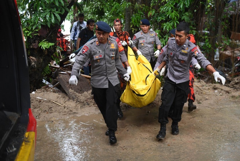 Polisi dan relawan mengevakuasi korban tewas akibat Tsunami yang tertimbun di bawah reruntuhan di kawasan Carita, Banten, Senin (24/12/2018).