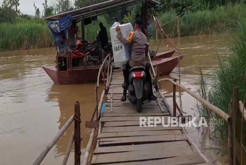 Polisi dan TNI di Indramayu harus menyeberangi sungai Cimanuk dengan menggunakan perahu tambangan dalam mendistribusikan Logistik Pilkada, di Desa Beduyut, Kecamatan Bangodua, Kabupaten Indramayu. 