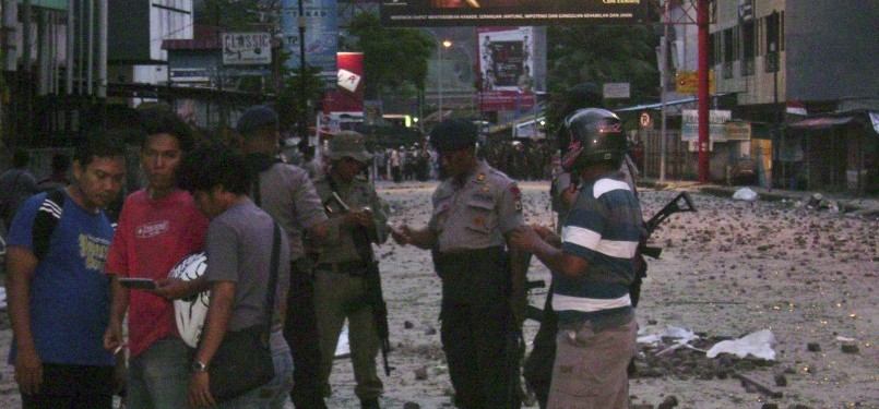Polisi dan warga berada di lokasi bekas-bekas kerusuhan di Kota Ambon