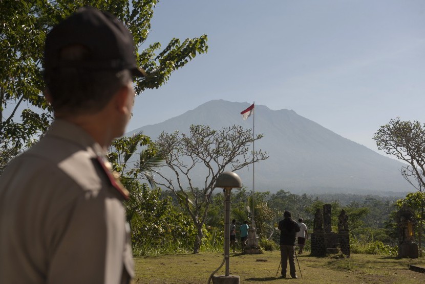 Polisi dan warga memantau aktifitas Gunung Agung di Pos Pemantauan Desa Rendang, Karangasem, Bali, Jumat (15/9).