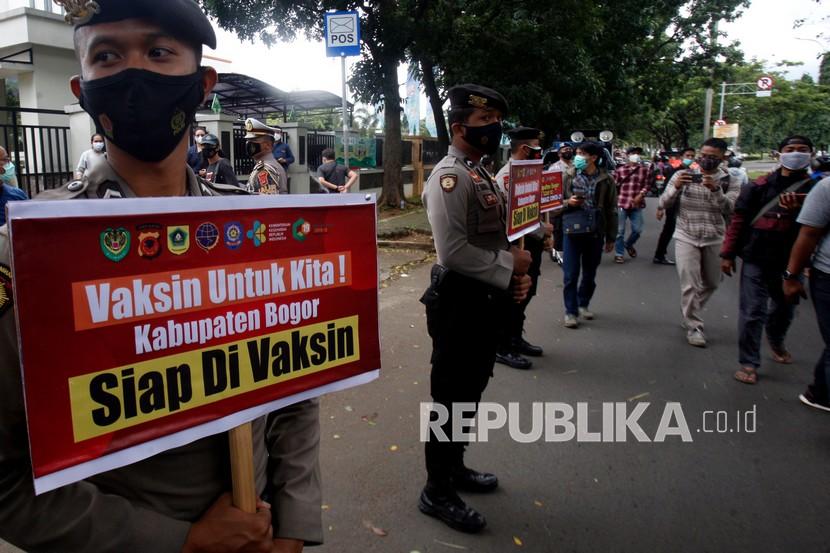 Polisi dari Polres Bogor mensosialisasikan vaksinasi COVID-19 di Jalan Raya Tegar Beriman, Cibinong, Kabupaten Bogor, Jawa Barat, Selasa (26/1/2021). Sosialisasi tersebut mengajak masyarakat untuk tidak takut melakukan vaksinasi COVID-19 yang disediakan oleh pemerintah. 