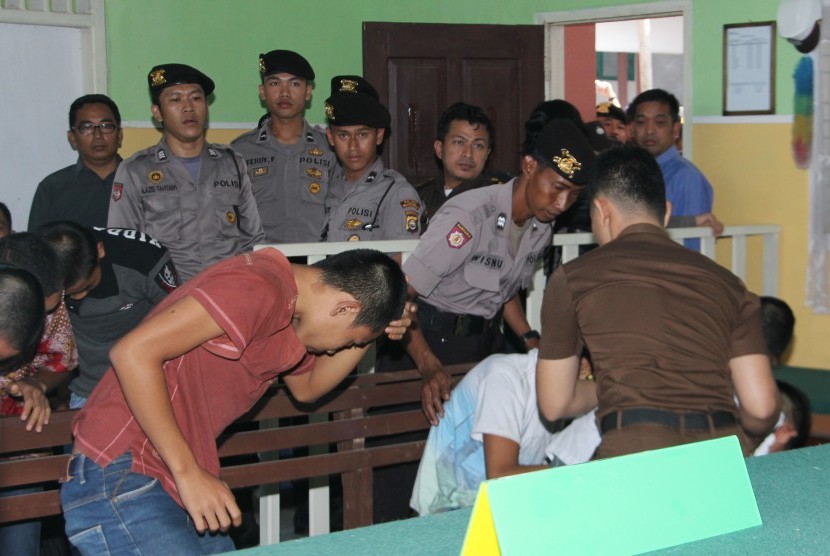 Polisi dari satuan Polres Rejang Lebong mengawal tujuh terdakwa anak kasus pemerkosaan YY saat memasuki ruang sidang anak di Pengadilan Negeri Curup, Rejang Lebong, Bengkulu, Selasa (10/5).