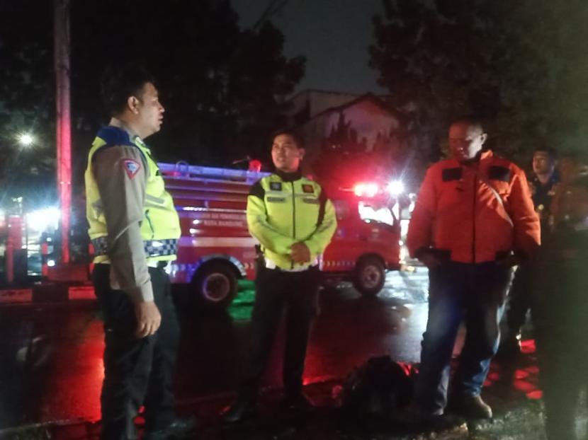 Polisi di lokasi meninggalnya pengendara motor asal Cipamokolan, Kota Bandung Dodih (60 tahun) usai lehernya tersangkut kabel listrik yang melintang turun di Jalan Peta Bandung, Ahad (25/2/2024) malam.