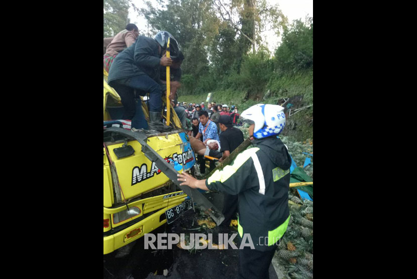 Polisi dibantu warga mengevakuasi korban kecelakaan di Jl Raya Puncak
