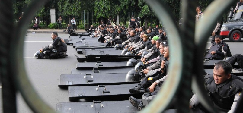 Polisi duduk menunggu aksi demonstrasi mahasiswa anti kenaikan harga BBM di Kawasan Monas, Jakarta, Selasa (27/3). (Republika/Wihdan Hidayat)