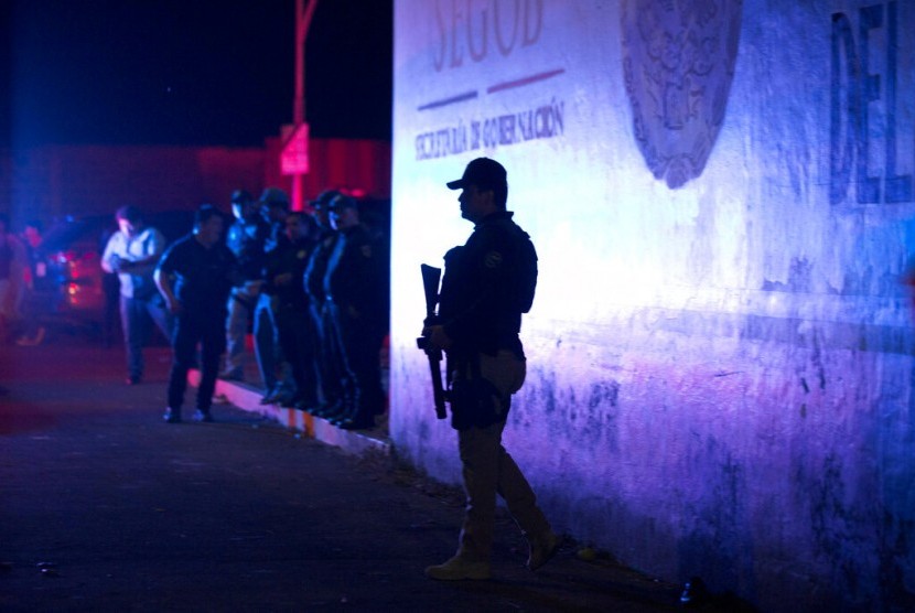 Polisi federal Meksiko berjaga di luar pusat penahanan imigrasi di Tapachula, Chiapas, Meksiko, Kamis malam (25/4). Lebih dari 1.000 migran kabur dari tempat tersebut.