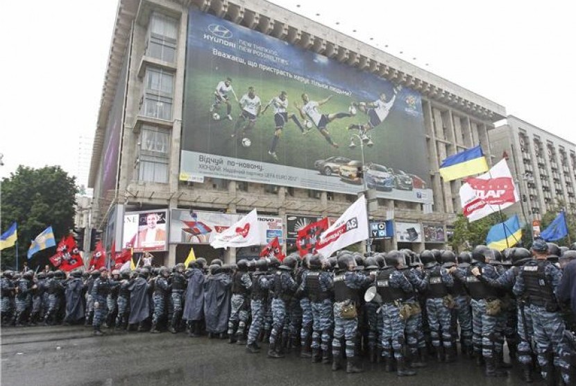 Polisi huru-hara memblokade demonstran yang melakukan aksi unjuk rasa dekat area yang akan digunakan untuk tempat layar lebar pertandingan di Independence Square, Kiev, Selasa (5/6). 