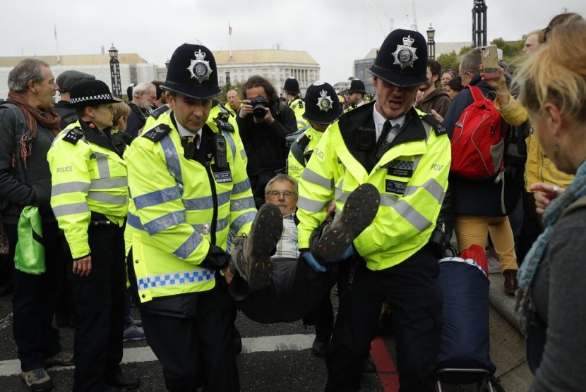 Polisi Inggris menangkap pendemo iklim di jembatan Lambeth di London, Senin (7/10). Pegiat lingkungan memblokir jalan menuju Parlemen Inggris.