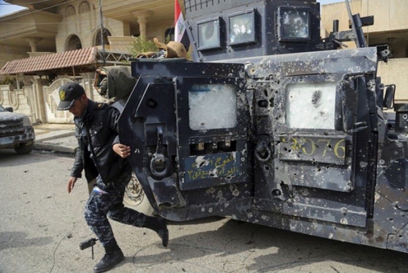 Polisi Irak keluar dari kendaraan perangnya yang rusak selama perang antara pasukan keamanan Irak dan militan ISIS di Mosul barat, Irak, Rabu, 1 Maret 2017.
