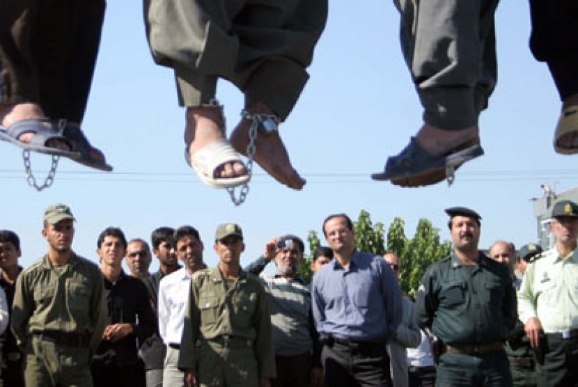 Polisi Iran, sejumlah pejabat pemerintah dan warga melihat eksekusi hukum gantung terdakwa yang divonis mati.