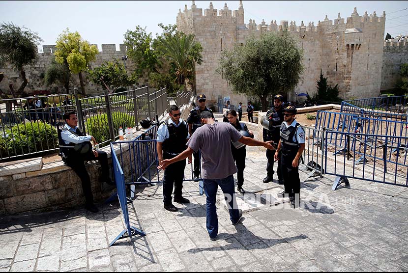 Polisi Israel memeriksa warga Palestina di pintu masuk  Kota Tua Yerusalem, Jumat (21/7)