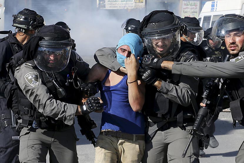 Polisi Israel menahan seorang pengunjuk rasa warga Palestina.