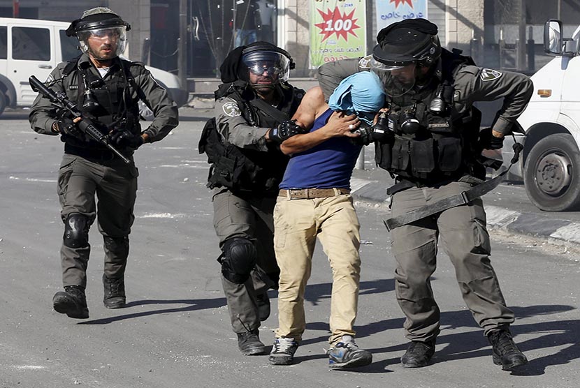 Polisi Israel menahan seorang pengunjuk rasa warga Palestina.